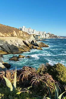 Images Dated 13th September 2022: Rocky coastline by Roca Oceanica with distant view of residential high-rise buildings in Renaca