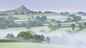 August Prints: Rolling mist covered countryside surrounding Brentor Church, Dartmoor, Devon, England