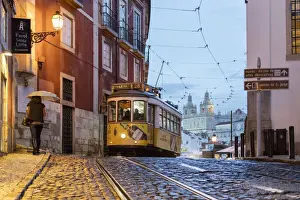 Oldest Prints: Romantic atmosphere in the old streets of Alfama with the castle in the background