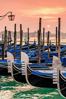 Canal Prints: Romantic sky at dawn over gondolas moored side by side on St Mark's waterfront