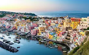 Crowded Prints: Romantic sunset over the colorful facades and harbor of Procida island