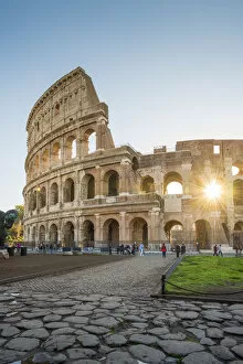 Rome, Lazio, Italy. Sun shines through the arches of the Colosseum