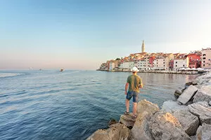 One Man Collection: Rovinj - Rovigno, tourist on the rocks of the pier admires the splendid old town, Istria