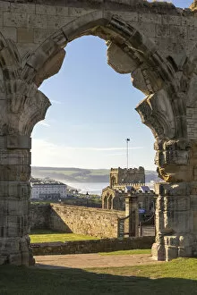 Ruined doorway of Whitby abbey frames the town, Whitby, North Yorkshire, England