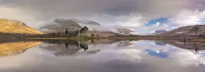 Images Dated 5th May 2020: The ruins of Kilchurn Castle reflected in Loch Awe at dawn on a misty morning in the