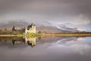 Images Dated 5th May 2020: The ruins of Kilchurn Castle reflected in Loch Awe at dawn on a misty morning in the