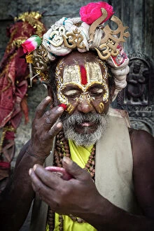Images Dated 14th September 2023: Sadhu (holy man) applying coloured powder at Pashupatinath Temple, Kathmandu, Nepal