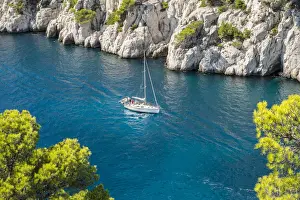 Calanques Prints: Sailboat passing through emerald blue water of Calanque de Port-Pin, Cassis