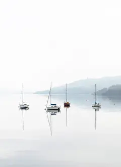 Sailing boats reflected in Windermere on a misty autumnal morning, Lake District National Park, Cumbria, England