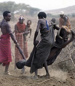 Tribal Jewelry Collection: A Samburu youth is forcibly restrained after throwing