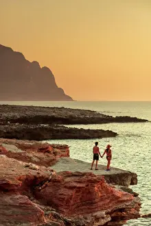 Geography Prints: San Vito lo Capo, Sicily. A couple enjoying the sunset on the rock formations along