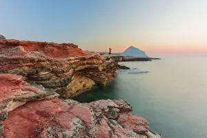 San Vito lo Capo, Sicily. A person enjoying the view of the sun setting along the rock