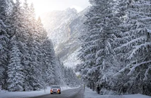 Images Dated 22nd January 2018: Scenic route with red car and snowy winter landscape, Dolomites Alps, Italy