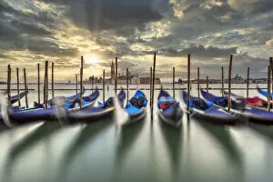 Scenic sunrise with moored gondolas and San Giorgio Maggiore island in the backdrop, Venice, Veneto, Italy