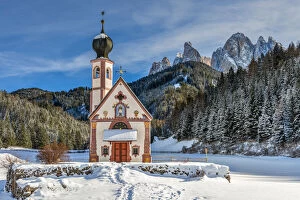 Picturesque Gallery: Scenic winter view over St Johann in Ranui church with Odle Dolomites behind