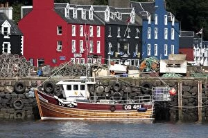 Scotland, Isle of Mull. Fishing boat and colourful waterfront houses at Tobermory harbour
