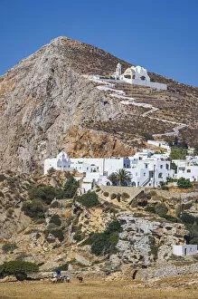 Goat Gallery: shepherd with goats and the Hora Village in Folegandros, Cyclades Islands, Greece