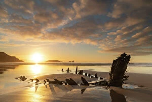 : Shipwreck of the Helvetia on the sandy shores of Rhossili Bay at sunset, Gower Peninsula