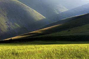Sibillini national park, Umbria, Italy. Ray of light between mountain ridges, with fields Sibillini national park, Umbria, Italy. Ray of light between mountain ridges, with fields
