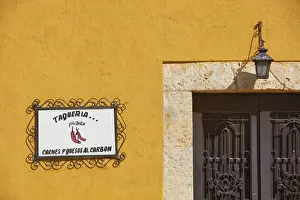 The signboard of a traditional Taqueria'restaurant in a street of Izamal, Yucatan, Mexico. Izamal is known in Yucatan as the Yellow City, as most of its buildings are painted yellow