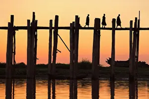 U Bein Prints: Silhouette of three Buddhists monks walking on the U-Bein wooden teak bridge at sunset