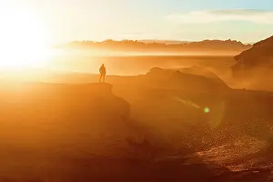 Exploration Prints: Silhouette of man watching sunrise over the Labyrinth Desert, Puna, Argentina. (MR)