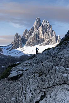 Solitude Gallery: Silhouette of woman on rocks looking at Croda Dei Toni mountain at dawn, Val Fiscalina