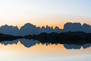 Two People Prints: Silhouettes of hikers admiring Brenta Dolomites at dawn from Lago Nero di Cornisello