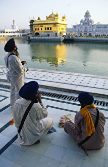Silk pilgrims pause beside the Amrit Sarovar