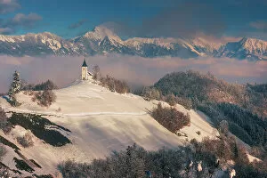 Images Dated 24th February 2023: Slovenia, Jamnik, Church of St. Primoz with the Kamnik-Savinja Alps beyond, Gorenjska