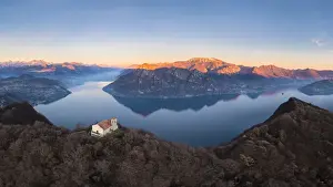 small church of Santuario della Santissima TrinitÔêÜÔÇá at the top of a mountain dominating Lake Iseo at sunset. Parzanica, Iseo Lake, Bergamo district, Lombardy, Italy