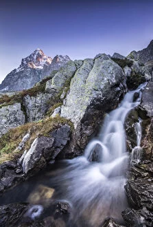 Peaks Gallery: Small waterfall at the foot of Mount Monviso illuminated by the first light of dawn