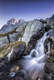 Piedmont Prints: Small waterfall at the foot of Mount Monviso illuminated by the first light of dawn