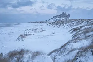 Dunes Prints: Snow covered beach and dunes on a wintry day at Bamburgh Castle in Northumberland