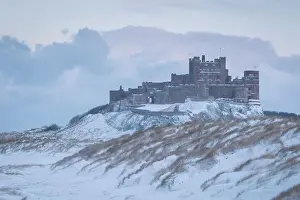 Northumberland Prints: Snow covered beach and dunes on a wintry day at Bamburgh Castle in Northumberland