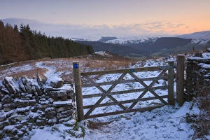Wales Collection: Snow covered gate and hilltop footpath on Allt yr Esgair with views to the Brecon Beacons mountains