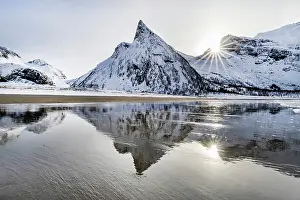 Troms County Prints: Snow covered Hatten mountain reflecting in wet sand on the beach at Ersfjord