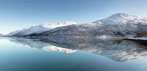 Snow Covered Prints: Snow-covered mountains with a perfect reflection in flat calm waters of a fjord