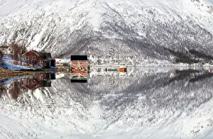 Troms Prints: Snow-covered mountains with a perfect reflection in flat calm waters of Sorfjorden
