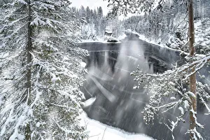 Ruka Prints: Snow storm over a forest and frozen river in winter