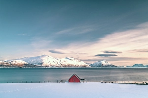 Cloudscape Prints: Snowcapped mountains and a lone red cabin along the fjord, Tromso, Norway