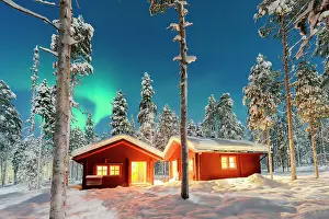 Aurora Borealis Prints: Snowy mountain huts in a frozen arctic forest under the bright night sky with Northern Lights