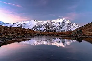 Mountain Peak Prints: Snowy peaks reflected in water at dawn, Val Cedec, Valtellina, Lombardy, Italy