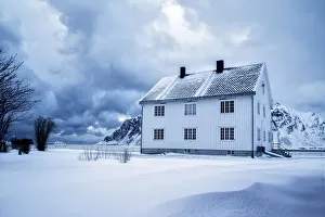 Solitude Gallery: A solitary house at dusk in the snow capped village of Flakstad. Lofoten islands. Norway