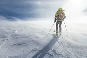 Wind Prints: Solitary Mountaineering skier climbing up during blizzard Alpe Devero, Lepontine Alps