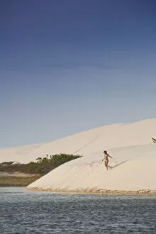 Images Dated 11th September 2012: South America, Brazil, Maranhao, a woman in a bikini descends a dune in the Lagoa