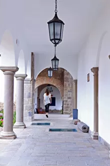 Colonial Style Gallery: South America, Peru, Cusco, a model walks along a cloister corridor in the Orient-Express