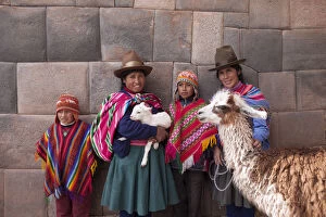 Incan Gallery: South America, Peru, Cusco. Quechua people standing in front of an Inca wall, holding
