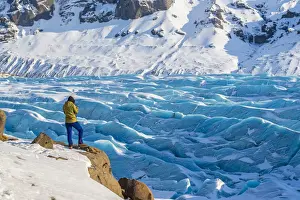 Southern Iceland, Europe. Woman in front of blue glacier in wintertime