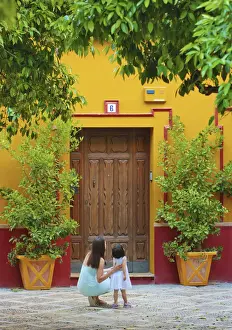 Andalusia Prints: Spain, Andalucia, Seville, Woman and child infront of traditional doorway (MR)
